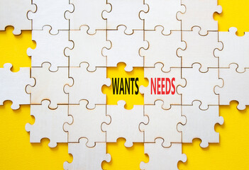 Wants and Needs symbol. Concept word Wants and Needs on wooden blocks. Beautiful yellow background....