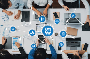 A vibrant business management meeting showcasing team collaboration around laptops and digital...