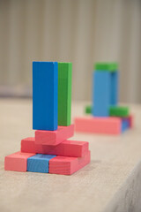 Colorful wooden blocks stacked on a surface. Playful objects to help develop children's fine motor skills, creativity, and early cognitive abilities.