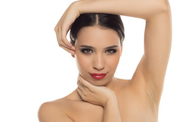 Studio shot on white background with woman posing with hands around face, red lips, and confident...
