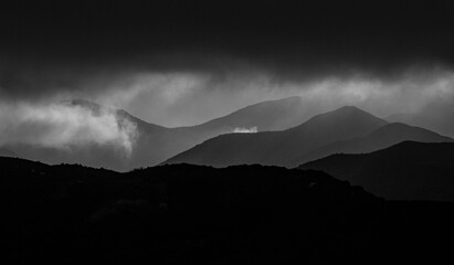 Dramatic black and white silhouette of mountains after a storm