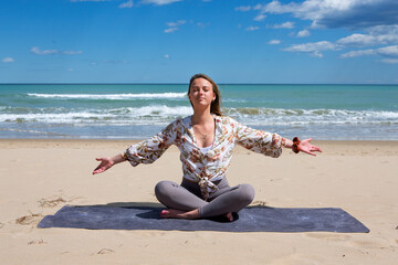 Woman meditating on beach with open arms