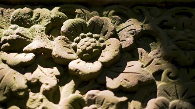 Stone carving of floral ornaments with aged mossy texture