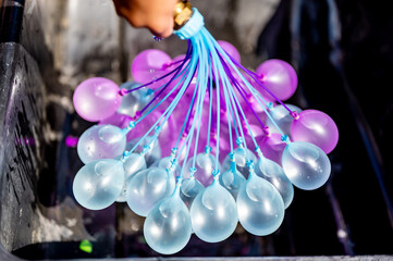 Rapid filling self sealing water balloons being inflated with a hose.