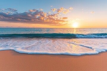 A serene beach scene at sunrise with gentle waves washing onto the sandy shore under a partly cloudy sky.