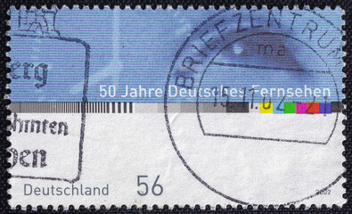 One eye, dial and parts of the TV test pattern on a 2002 Germany vintage postage stamp dedicated to...