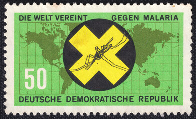 Yellow Cross with gnat on a 1963 GDR postage stamp. Fight against Malaria Series.