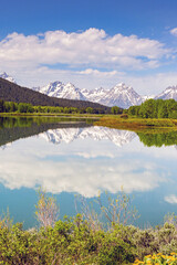 Scenic view of snow capped mountains in the Grand Teton National Park reflected in the still waters of a lake. No people.