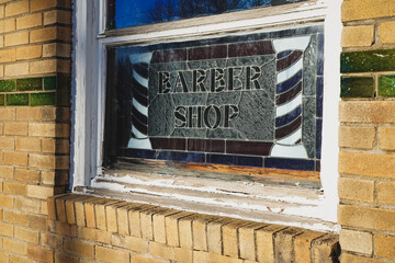 A historic stained glass window at an abandoned barber shop.