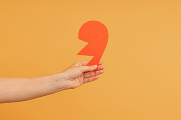 A hand presenting a red paper cutout of a lightning bolt.