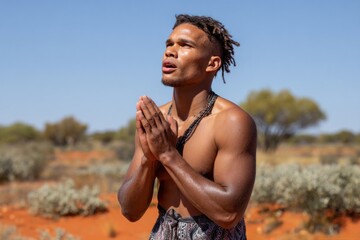 Indigenous man praying in the australian outback desert