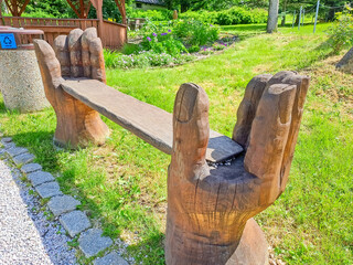 Harrachov- Czech- 26 June 2025: Hand-carved wooden bench in the city park