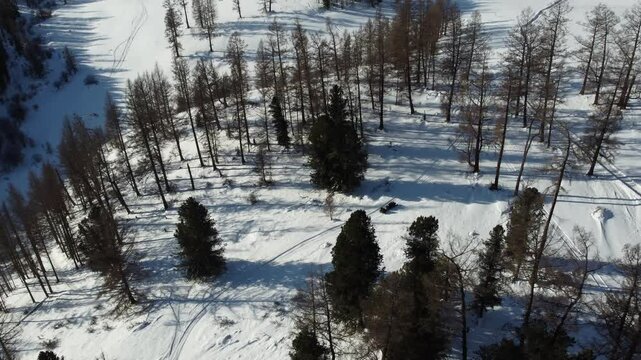 Drone aerial footage of a snowmobile riding across a frozen lake and snowy terrain in Russia. Captured from various angles, this footage highlights winter adventure, remote wilderness