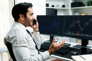 Trader businessman calling to consultant or partner with two stock exchange investment, compare...