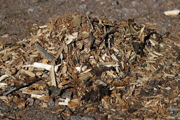 A pile of wood chips on the ground, ideal for landscape or garden use