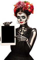 Smiling woman in skeleton makeup with floral crown showing screen of digital tablet. Concept of...