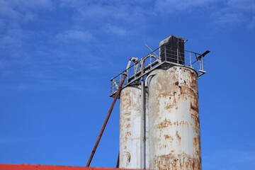Abandoned industrial site with rusty machinery and a clear blue sky