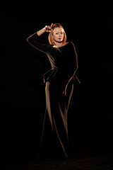 Woman in a black dress posing on a black background