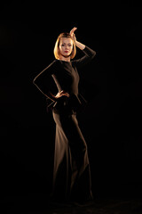 Woman in a black dress posing on a black background