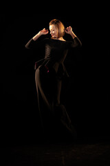 Woman in a black dress posing on a black background
