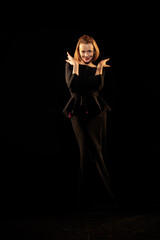 Woman in a black dress posing on a black background