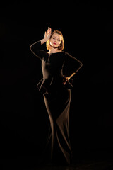 Woman in a black dress posing on a black background
