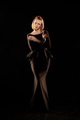 Woman in a black dress posing on a black background