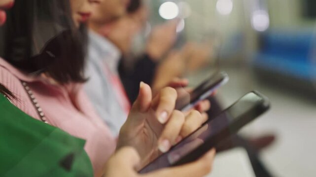 Young people using mobile phone in public underground train . Urban city lifestyle and commuting in Asia concept .