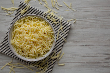 Organic Shredded Mozzarella Cheese in a Bowl, top view. Copy space.