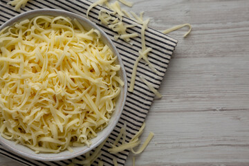 Organic Shredded Mozzarella Cheese in a Bowl, top view. Copy space.