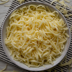 Organic Shredded Mozzarella Cheese in a Bowl, top view. Close-up.