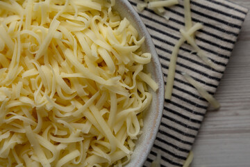 Organic Shredded Mozzarella Cheese in a Bowl, top view. Close-up.
