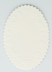 Decorative white oval label with intricate edges displayed on neutral background