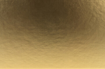 Gold metallic background with subtle texture reflecting light and warmth