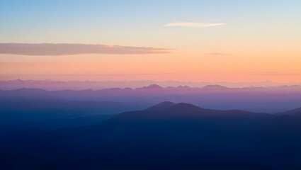 Fototapeta premium Aerial view of mountain range at sunrise with pastel sky and soft light scenery
