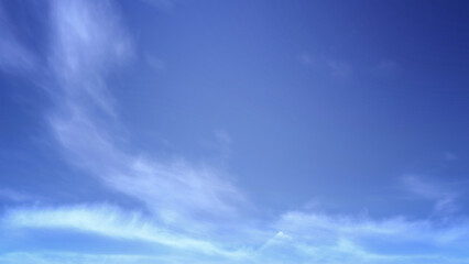 Obraz premium Vivid blue sky filled with soft, fluffy white clouds. Ideal for nature backgrounds, serene landscapes, or optimistic and inspirational themes.