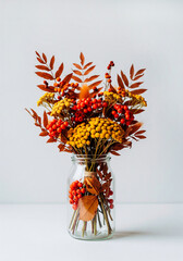 Autumn bouquet with colorful fall leaves in glass vase for seasonal decor, greeting cards or cozy branding visuals