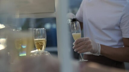 Bartender pouring champagne into flute glasses outdoors - Powered by Adobe