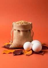 Rustic fall still life with eggs in linen pouch and autumn leaves for seasonal design, blog or eco food concept