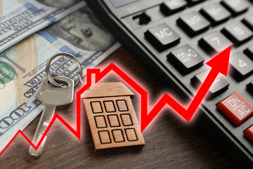 Increase in real estate value. House key, money and calculator on table. Growing price represented...
