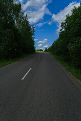 Fototapeta premium Highway wide road, transport and blue sky with clouds on a summer day