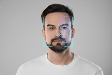 Facial recognition system. Scanning man's face for authentication against light grey background