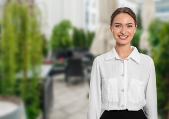 Young smiling hostess in uniform at outdoor restaurant