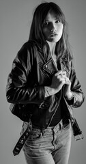 Black and white portrait of fashionable young woman wearing leather jacket and jeans