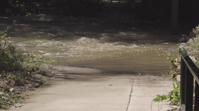 Texas 2025 flood water covering park trail sidewalk