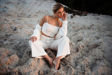 Woman in White Outfit Sitting on Beach