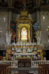 Altar of the Chapel of the Madonna del Conforto with reliquary, Baroque decoration, flowers, and...
