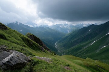 Obraz premium Dramatic cloudy sky over lush green mountain valley panorama