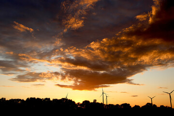 Wind turbines silhouette at sunset with dramatic sky