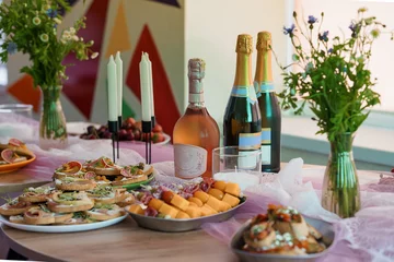 Fotobehang Eetkamer Elegant Champagne Brunch Spread on Pink Tablecloth with Flowers and Candles, Vibrant Interior Background, Festive Party Still Life.  © Galka3250
